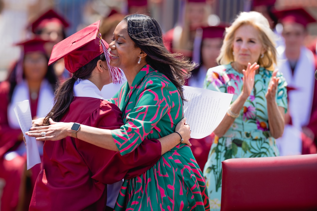 Renee Cobb the principal Matthew C. Perry High School hugs a member of the graduating class during a ceremony at Marine Corps Air Station Iwakuni, Japan, May 21, 2023. Biden visited MCAS Iwakuni as part of the Joining Forces initiative which focuses on supporting veteran families, caregivers, and survivors. (U.S. Marine Corps photo by Cpl. Raymond Tong)