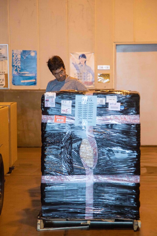 A Master Labor Contractor with the Marine Corps Air Station Iwakuni Distribution Management Office secures cargo for transportation at MCAS Iwakuni, Japan, June 15, 2023. MLCs within the Distribution Management Office help break down the language barrier, make transportation arrangements, and communicate with local transportation services. (U.S. Marine Corps Photo by Cpl. Calah Thompson)