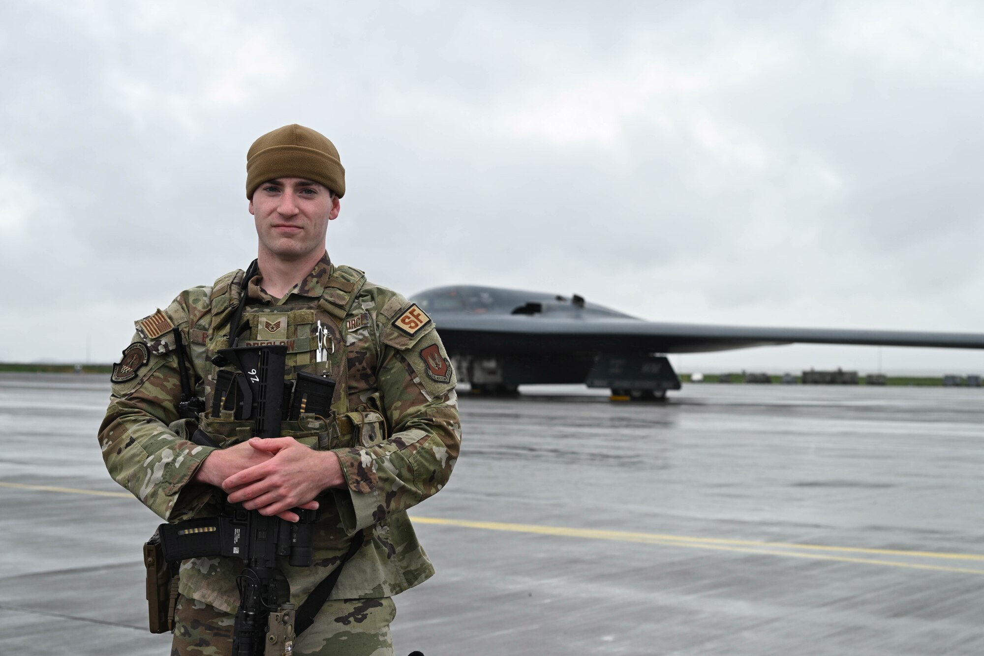 Airman stands in front of an aircraft.