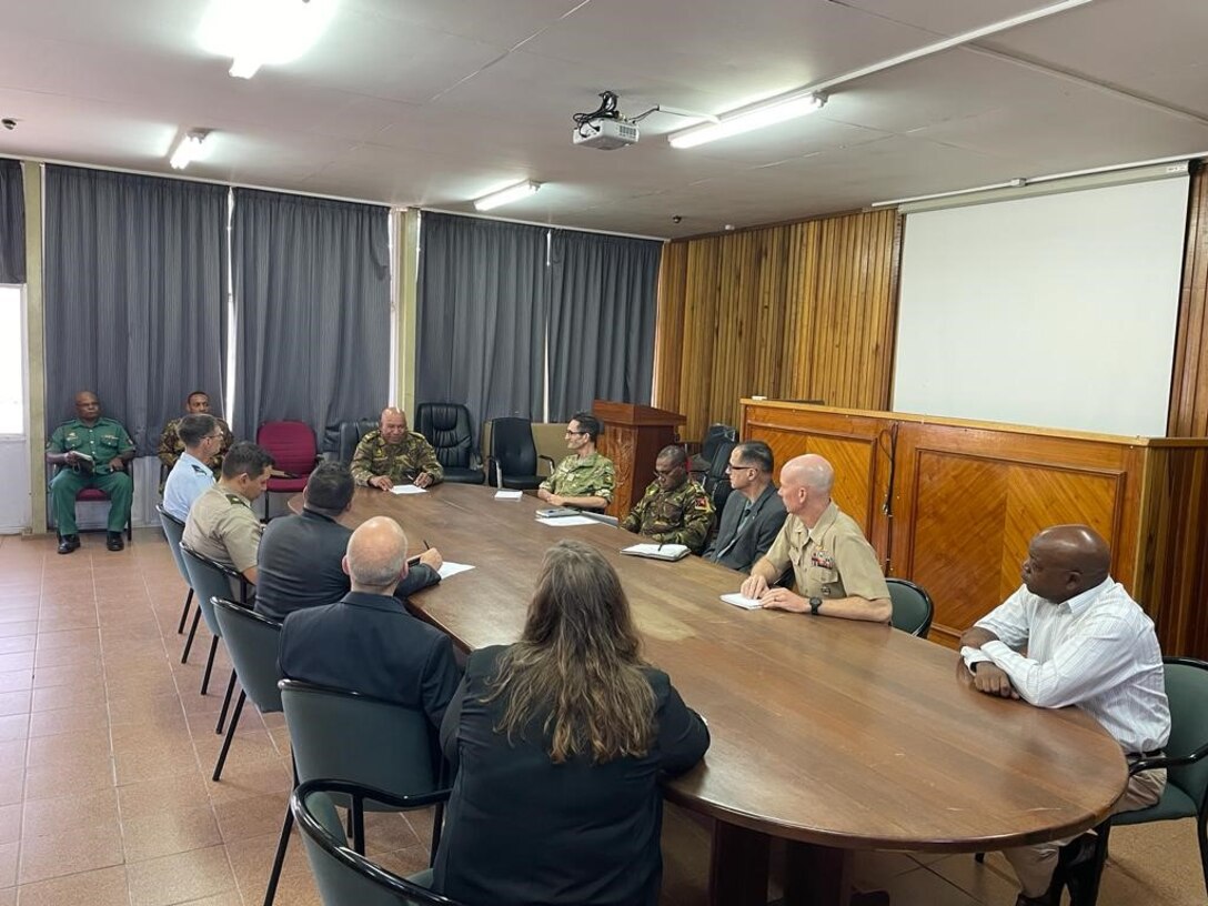 men and women in uniform sit at conference table