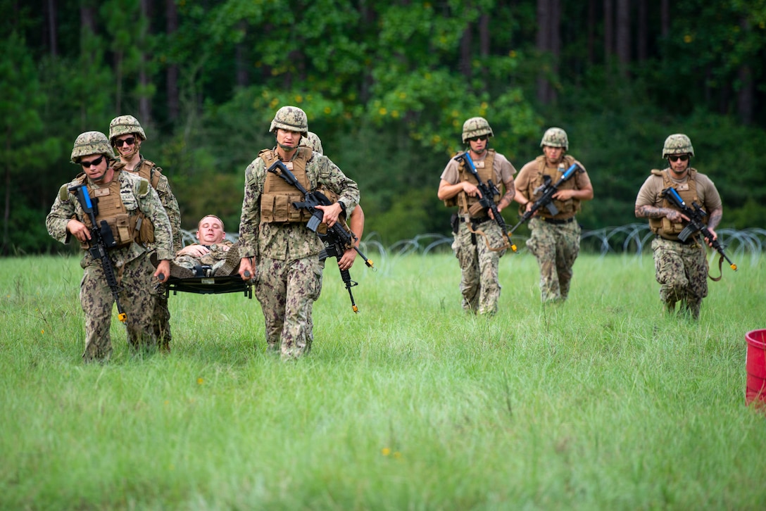 Seabees assigned to Naval Mobile Construction Battalion (NMCB) 11,  transport a simulated casualty during "Operation Turning Point", a field training exercise (FTX) on Camp Shelby, Miss., August 8, 2023.