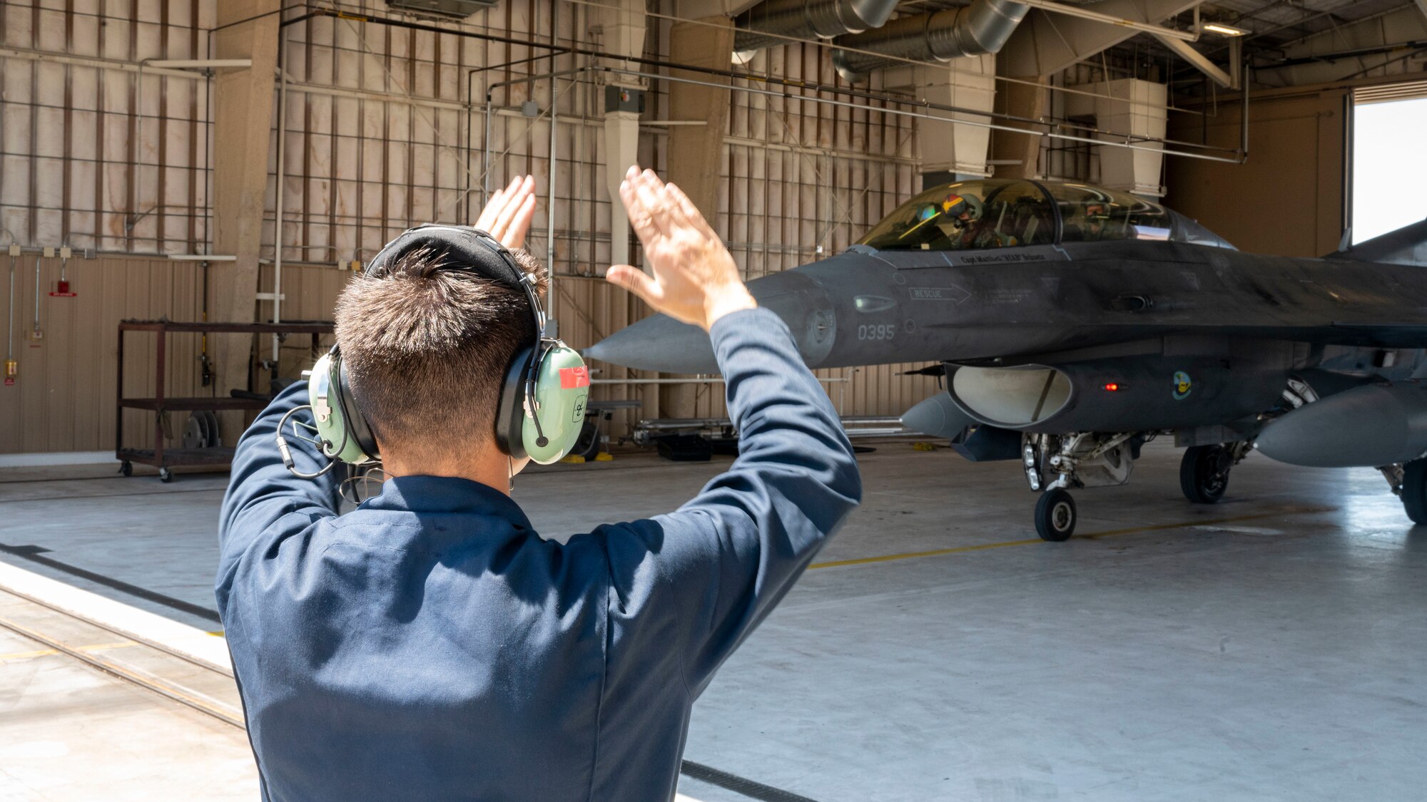 U.S. Air Force Senior Airman Tristan Bunce, 311th Aircraft Maintenance Unit assistant dedicated crew chief, marshals an F-16 Viper at Holloman Air Force Base, New Mexico, Aug. 15, 2023.
