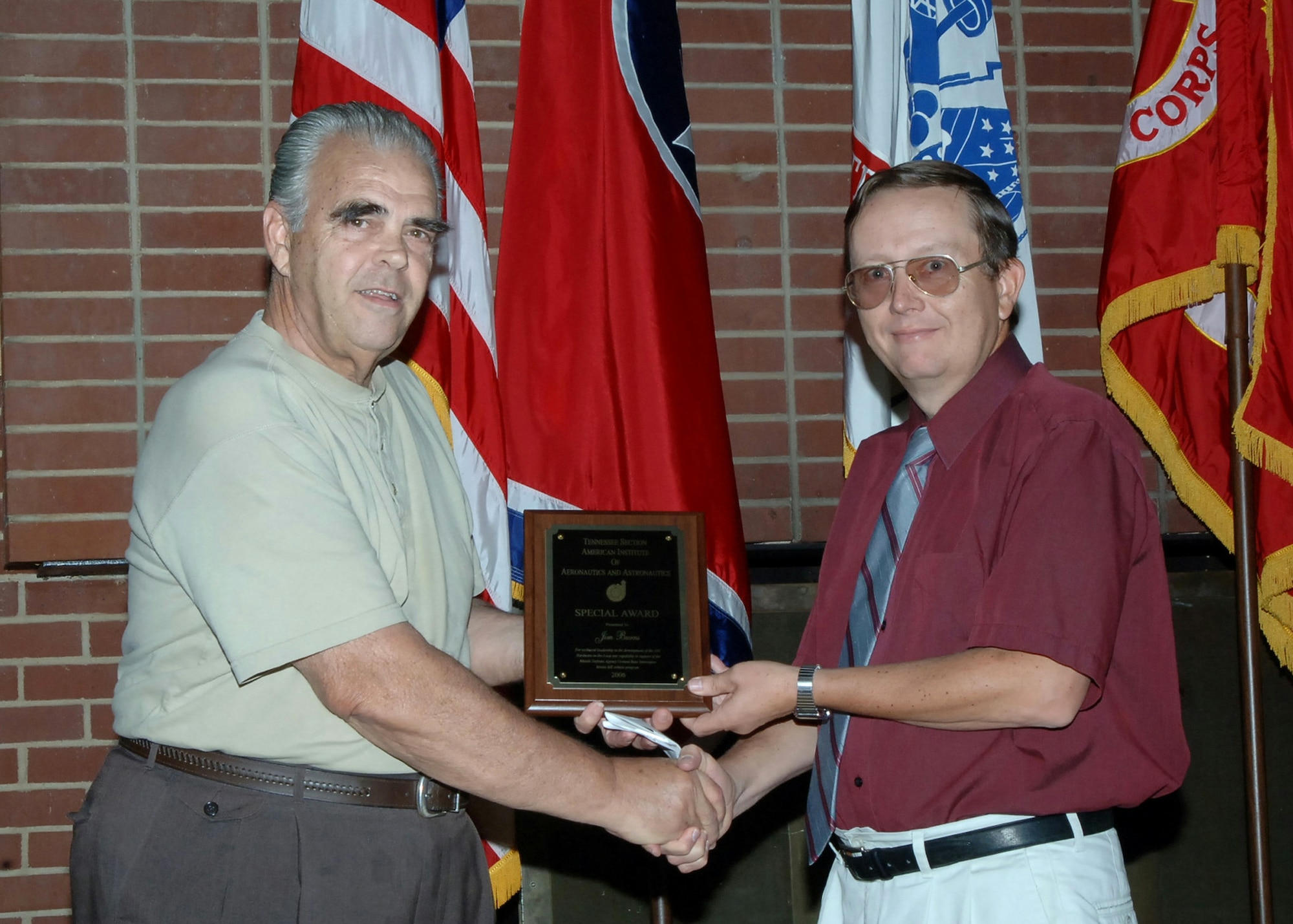 Dale Bradley, then technical director for the Arnold Engineering Development Complex 718th Test Squadron, presents an American Institute of Aeronautics and Astronautics special award to fellow AEDC employee Jim Burns during a June 2006 ceremony at Arnold Lakeside Complex at Arnold Air Force Base, Tenn. (U.S. Air Force photo)