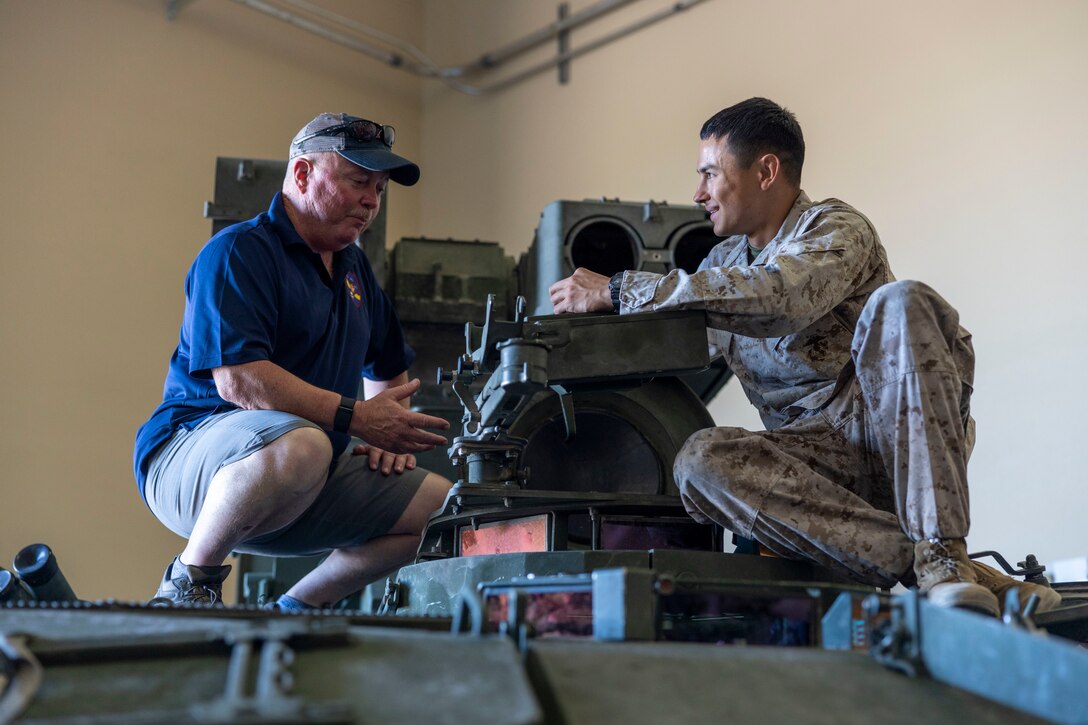 A retired U.S. Marine from 3rd Light Armored Reconnaissance (LAR) Battalion, (left) speaks to Lance Cpl. Joshua Day, machine gunner during a “Wolfpack Reunion” at Marine Corps Air Ground Combat Center, Twentynine Palms, California, July 21, 2023. The Wolfpack Association holds a reunion for active and retired members of the LAI/LAR community to reconnect and honor those who served in the unit throughout the years. (U.S. Marine Corps photo by Lance Cpl. Jacquilyn Davis)