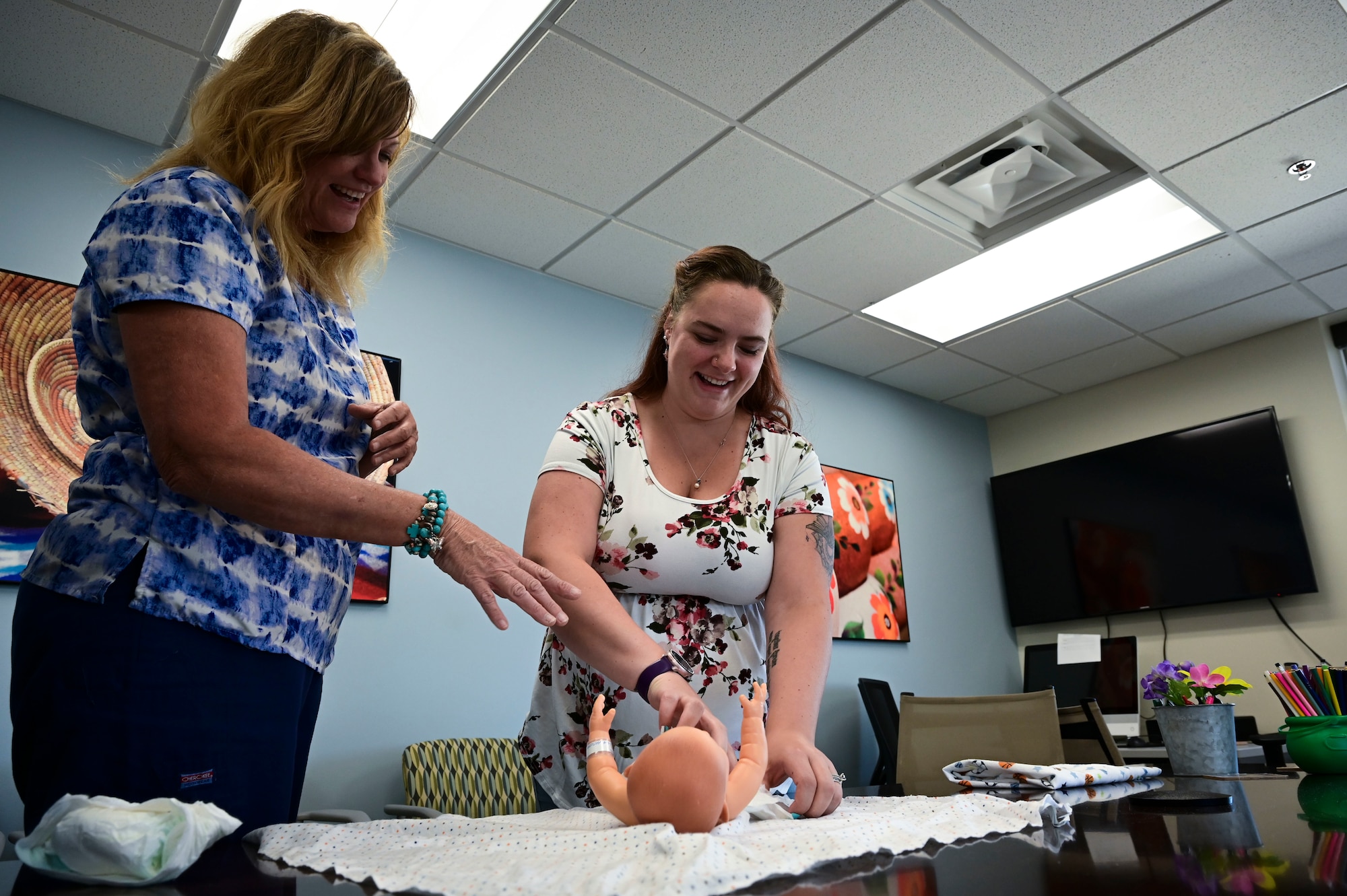 Candi Hutchins, 49th Medical Group parent support nurse, left, shows Katie Novotney, 49th MDG mental health receptionist, how to place a diaper on a doll during a Parents 101 class at Holloman Air Force Base, New Mexico, Aug. 16, 2023. The program is primarily geared towards parents in their third trimester, or for parents who need a refresher course on newborn or child management care. (U.S. Air Force photo by Airman 1st Class Isaiah Pedrazzini)