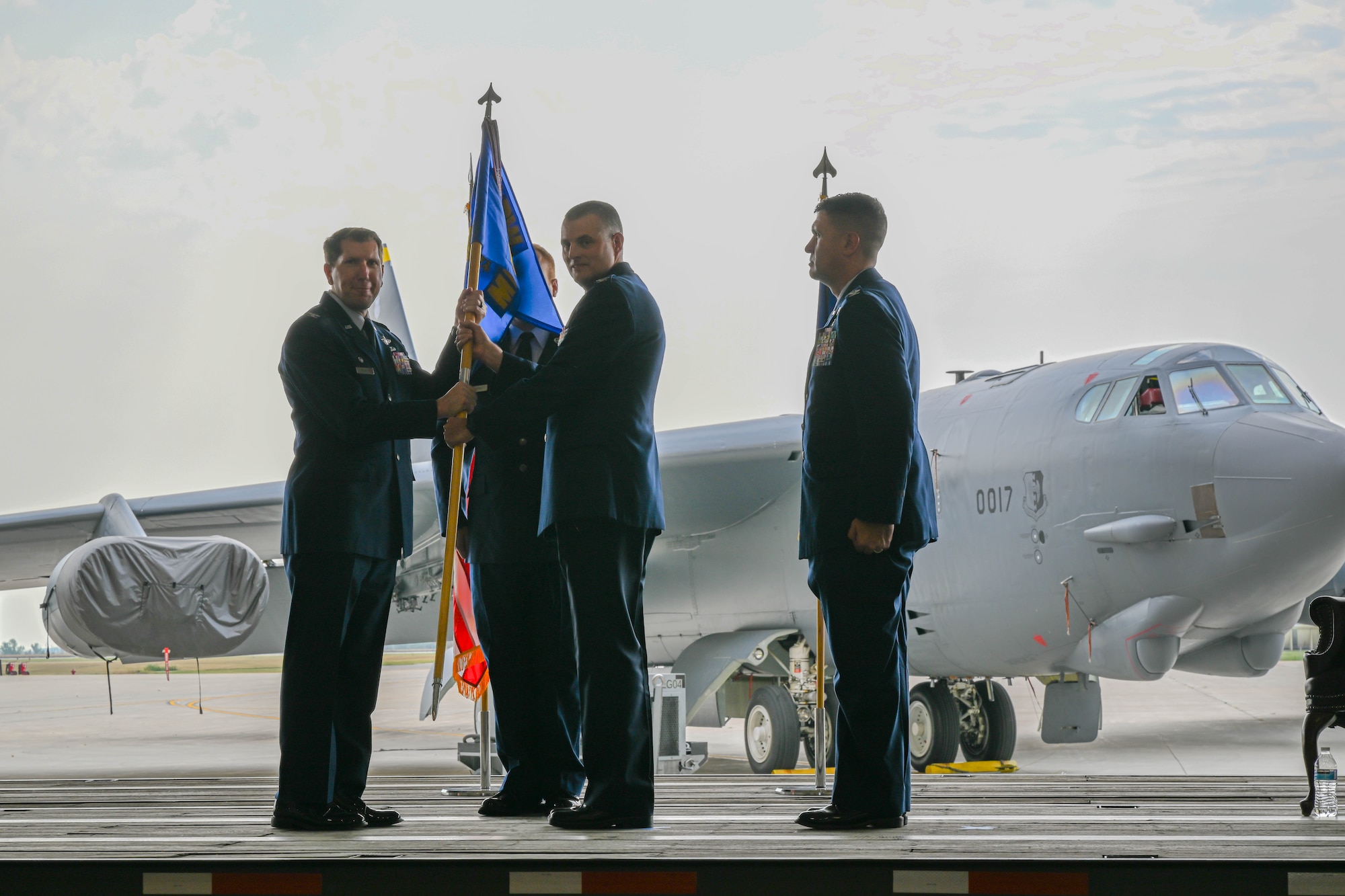 U.S. Air Force Col. Joel Dixon, outgoing 5th Medical Group (MDG) commander, passes the guidon to U.S Air Force Col. Daniel Hoadley, 5th Bomb Wing commander, during the 5th MDG change of command ceremony at Minot Air Force Base, North Dakota, Aug. 18, 2023. Dixon served as commander of the 5th MDG since June 2021. (U.S. Air Force photo by Airman 1st Class Kyle Wilson)