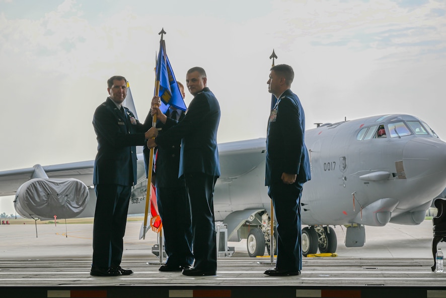 U.S. Air Force Col. Joel Dixon, outgoing 5th Medical Group (MDG) commander, passes the guidon to U.S Air Force Col. Daniel Hoadley, 5th Bomb Wing commander, during the 5th MDG change of command ceremony at Minot Air Force Base, North Dakota, Aug. 18, 2023. Dixon served as commander of the 5th MDG since June 2021. (U.S. Air Force photo by Airman 1st Class Kyle Wilson)