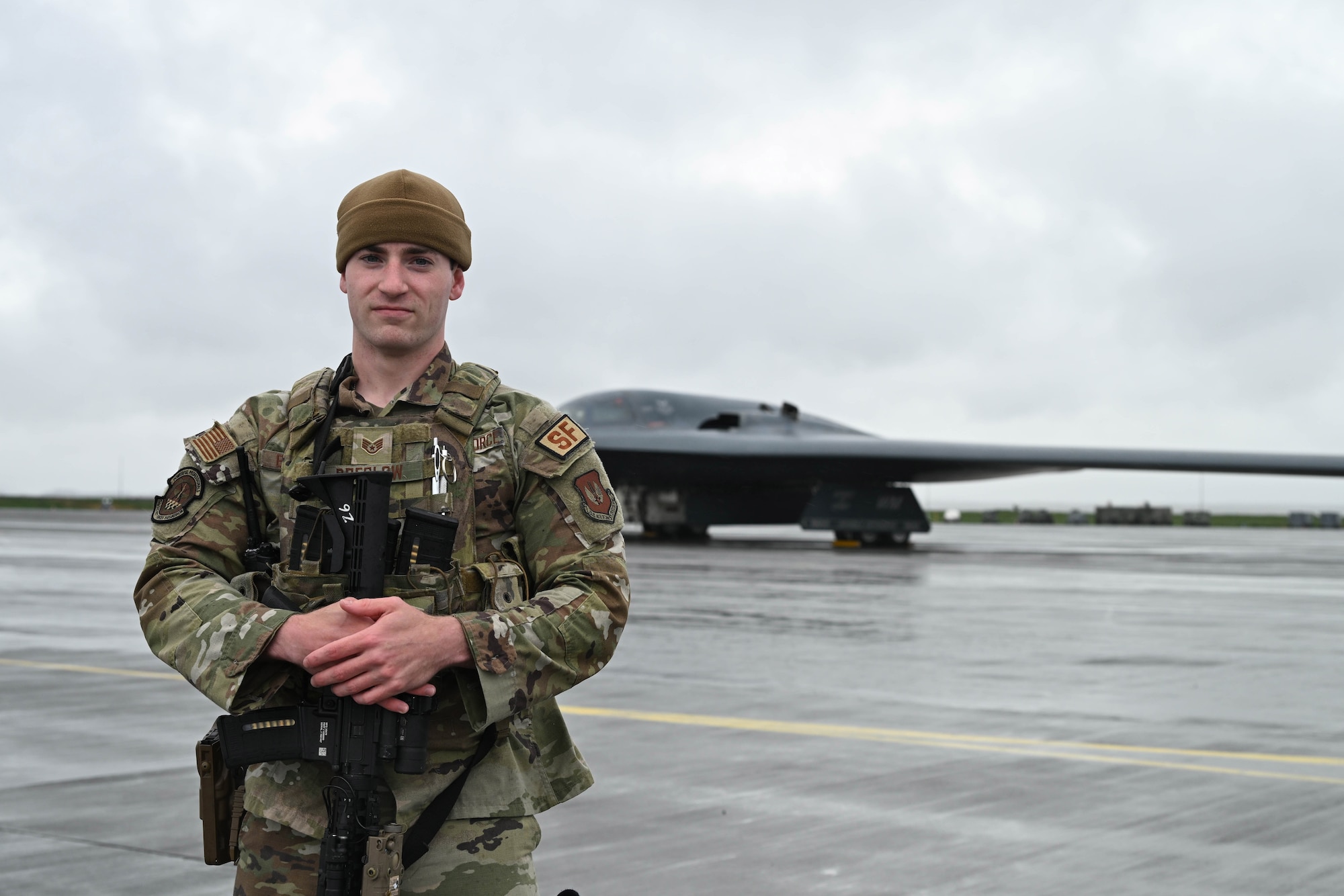 Airman stands in front of an aircraft.