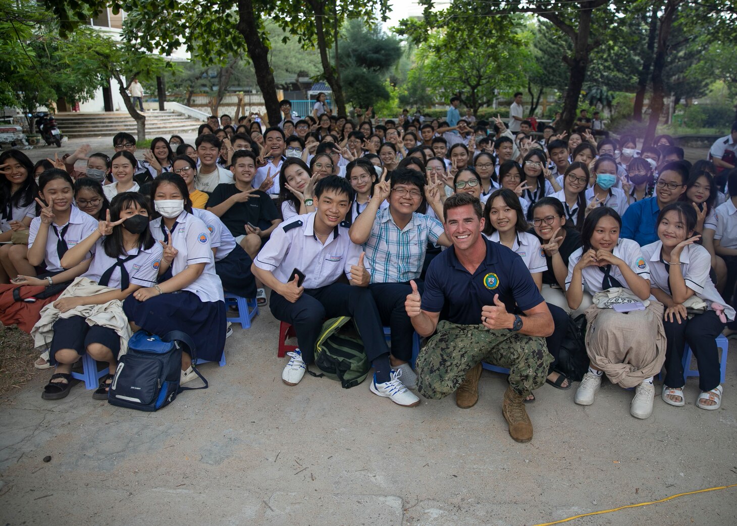 Lt. Jackson Welch, Pacific Partnership 2023 legal officer, poses for a photo with students from the Luong Van Chanh School before a concert featuring the Pacific Partnership 2023 Band and students from the school, Aug. 14. Now in its 18th year, Pacific Partnership is the largest annual multinational humanitarian assistance and disaster relief preparedness mission conducted in the Indo-Pacific.