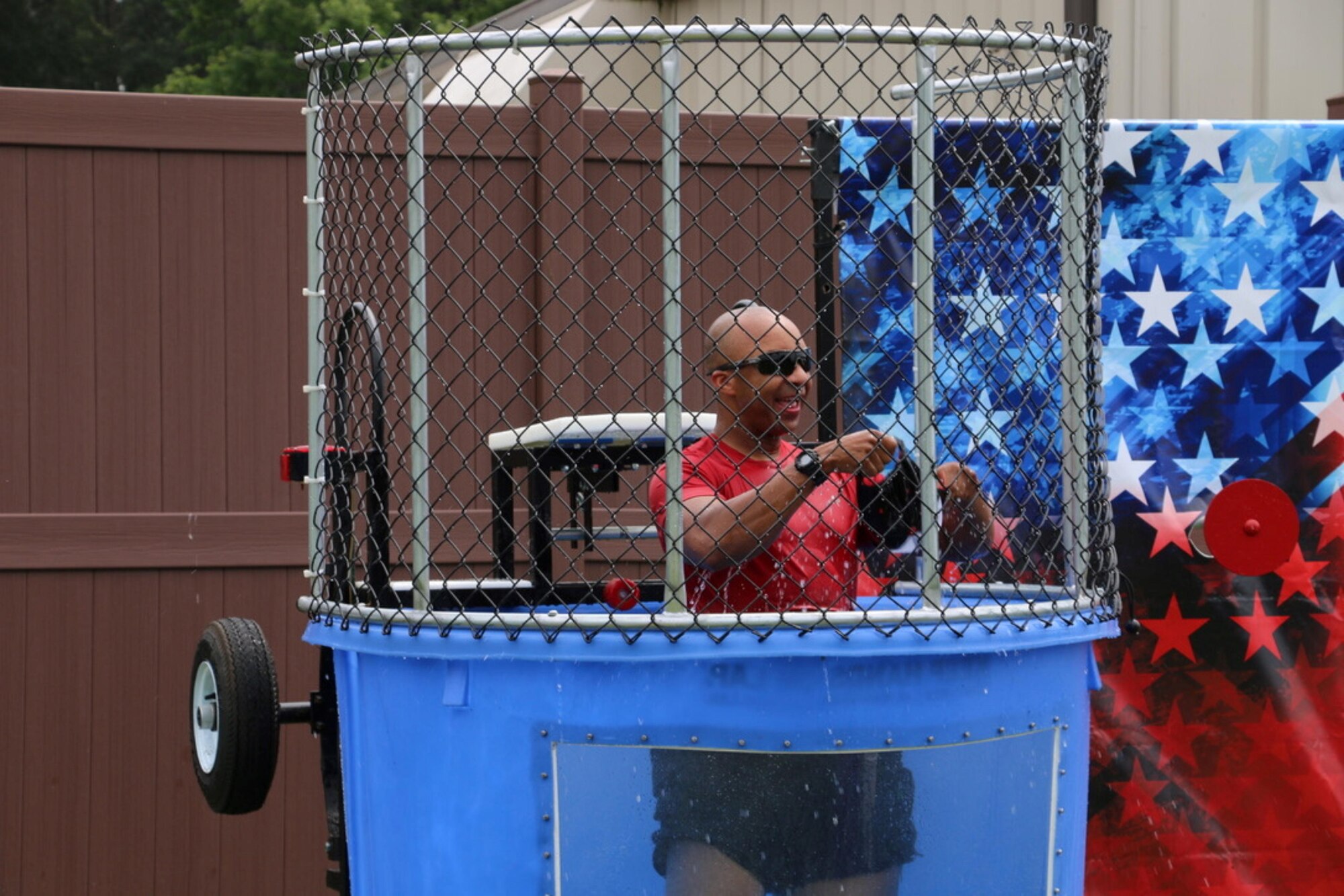 Arnold Engineering Development Complex Commander Col. Randel Gordon is soaked after taking a turn in the dunking booth at the first-ever Arnold Air Force Base Services SummerFest Aug. 12, 2023, at the Gossick Leadership Center on Arnold Air Force Base, Tenn. Along with the dunking booth, the event featured pie eating contests, a cardboard boat race, a car show, bounce houses and food trucks, among other activities. (U.S. Air Force photo by Jodee George)