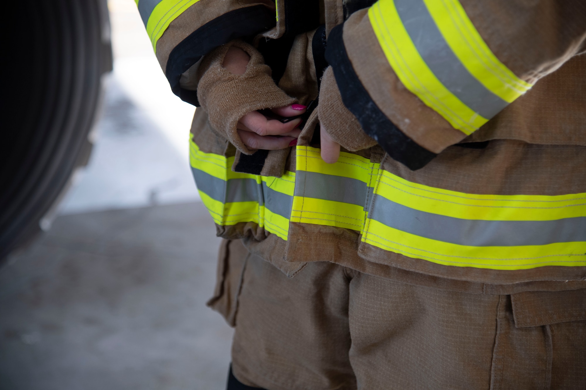 Close-up picture of firefighter's hands fastening a coat