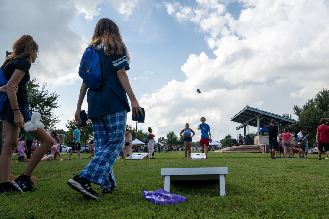Children play a game of corn hole during the Fort Eustis Block Party at Joint Base Langley-Eustis, Virginia, August 17, 2023.