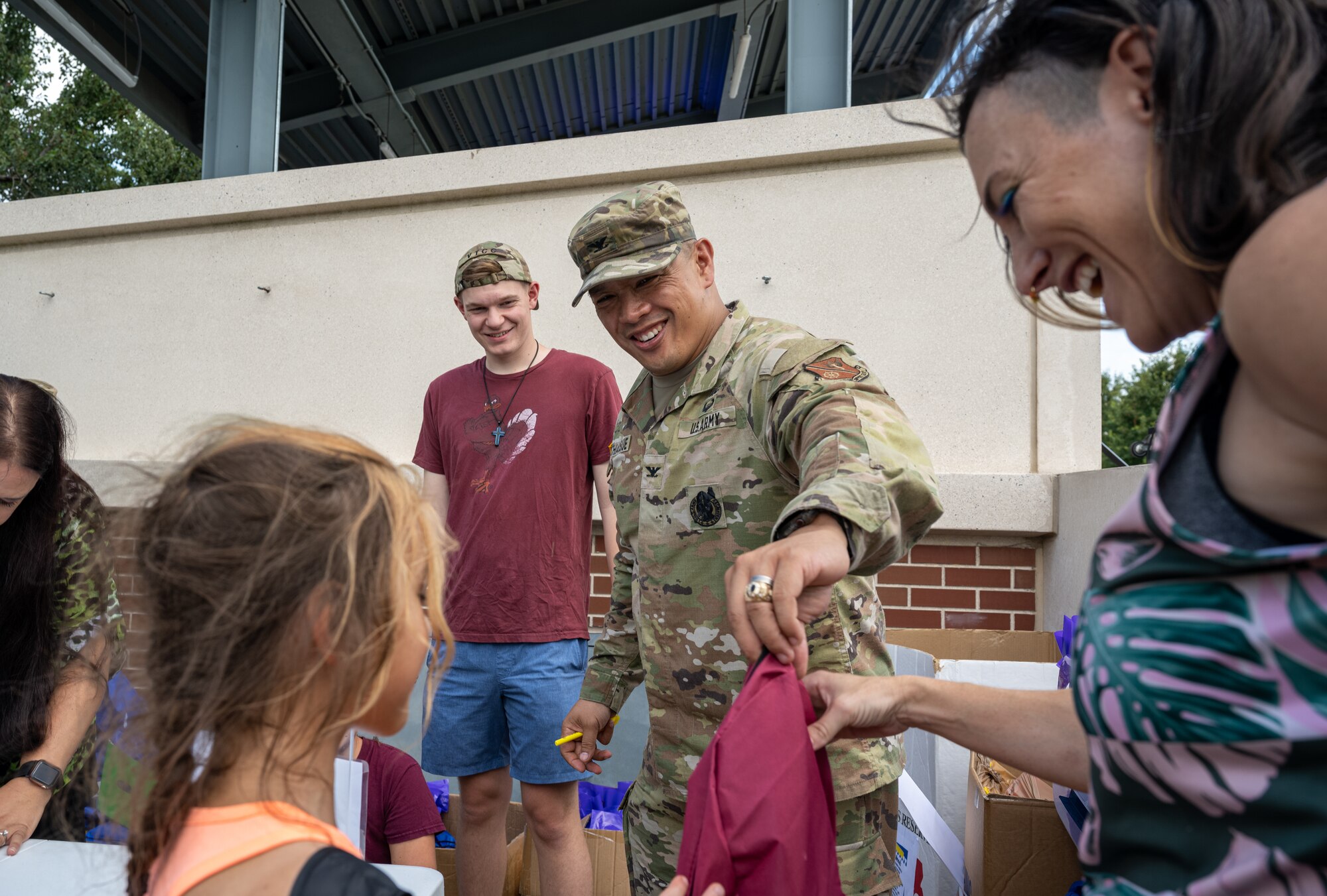 U.S. Army Col. Frankie Cochiaosue, 733d Mission Support Group commander, hands out backpacks filled with school supplies to elementary school children during the Fort Eustis Block Party at Joint Base Langley-Eustis, Virginia, Aug. 17, 2023.