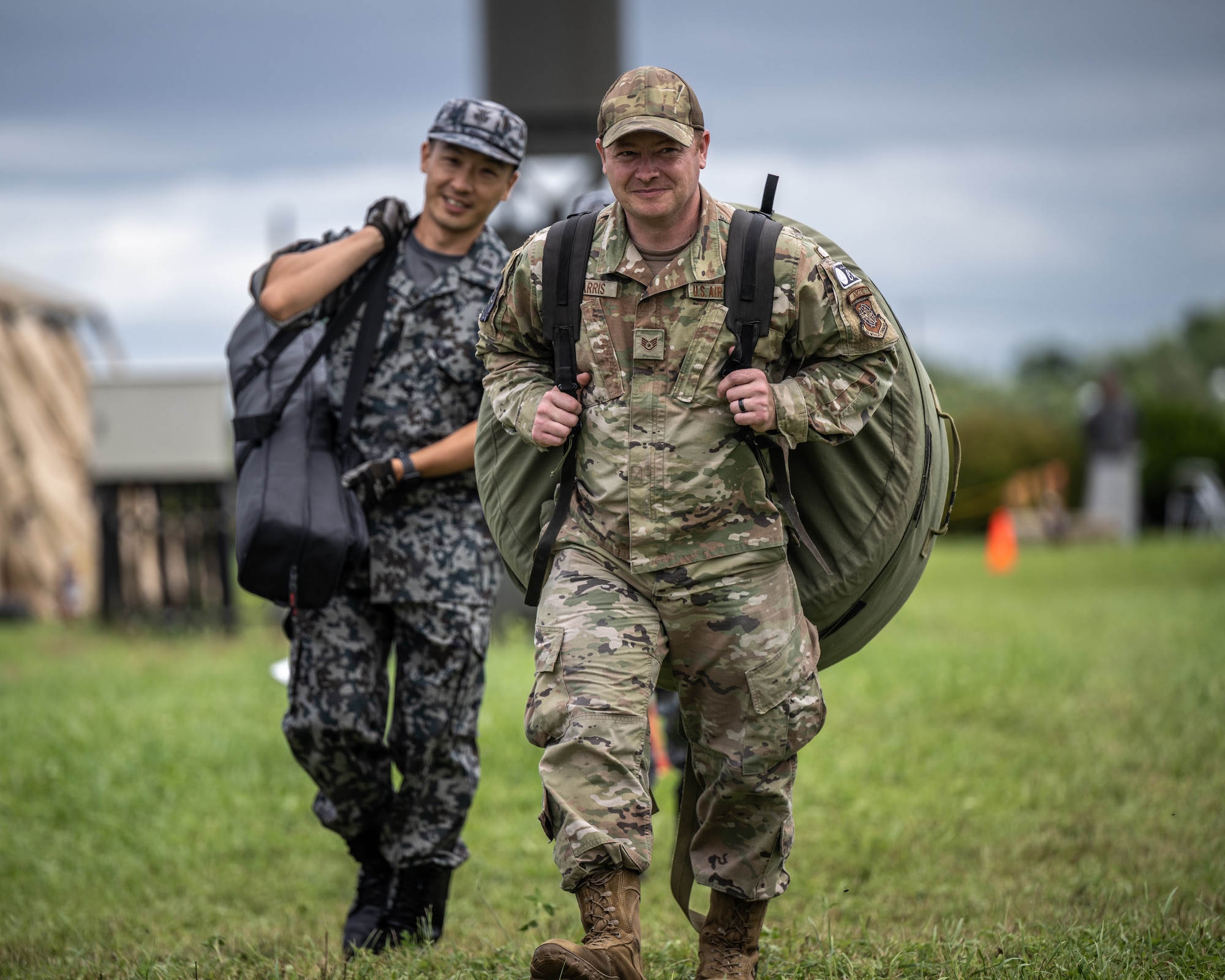 U.S. Air Force Staff Sgt. Calen Zarris, an Airman assigned to the 921st Contingency Response Squadron carries  supplies with a Japanse Air Self Defense Force Airman during a site visit to Yakumo Air Base, Japan July 13, 2023, in support of Mobility Guardian 2023. A multilateral endeavor, MG23 features seven participating countries – Australia, Canada, France, Japan, New Zealand, United Kingdom, and the United States – operating approximately 70 mobility aircraft across multiple locations spanning a 3,000 mile exercise area from July 5th through July 21. Our Allies and partners are one of our greatest strengths and a key strategic advantage. MG23 is an opportunity to deepen our connections with regional Allies and partners using bold initiatives. (U.S. Air Force photo by Tech. Sgt. Alexander Cook)