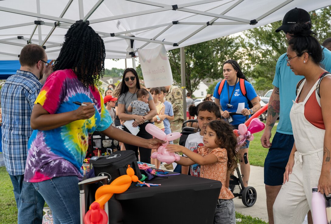 Volunteers create balloon animals for military children as part of the festivities during the Fort Eustis Block Party at Joint Base Langley-Eustis, Virginia, August 17, 2023.