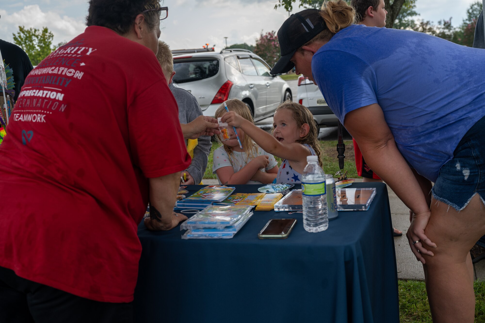 Children from military families collect donated school supplies from various tables at the Fort Eustis Block Party at Joint Base Langley-Eustis, Virginia, August 17, 2023.