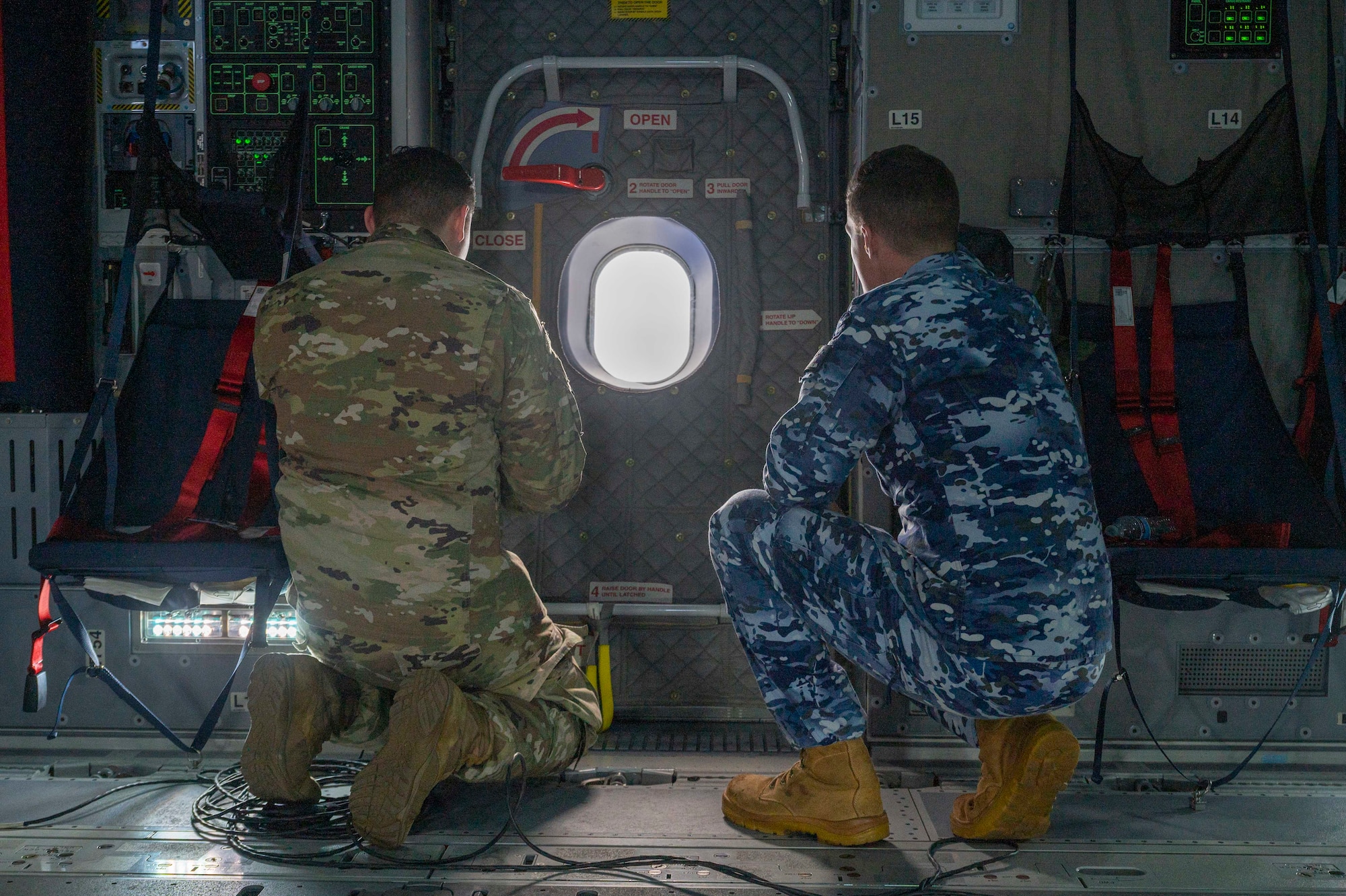 A U.S. Air Force Airman and a Royal Australian Air Force aviator look out the window of a Royal Air Force A400M Atlas during a familiarization flight over Hawaii during Mobility Guardian 23, July 10, 2023. MG23 features seven participating countries - Australia, Canada, France, Japan, New Zealand, United Kingdom, and the United States - operating approximately 70 mobility aircraft across multiple locations spanning a 3,000 mile exercise area. Our Allies and partners are one of our greatest strengths and a key strategic advantage. MG23 is an opportunity to deepen our connections with regional Allies and partners using bold initiatives. (U.S. Air Force photo by Senior Airman Tiffany Del Oso)