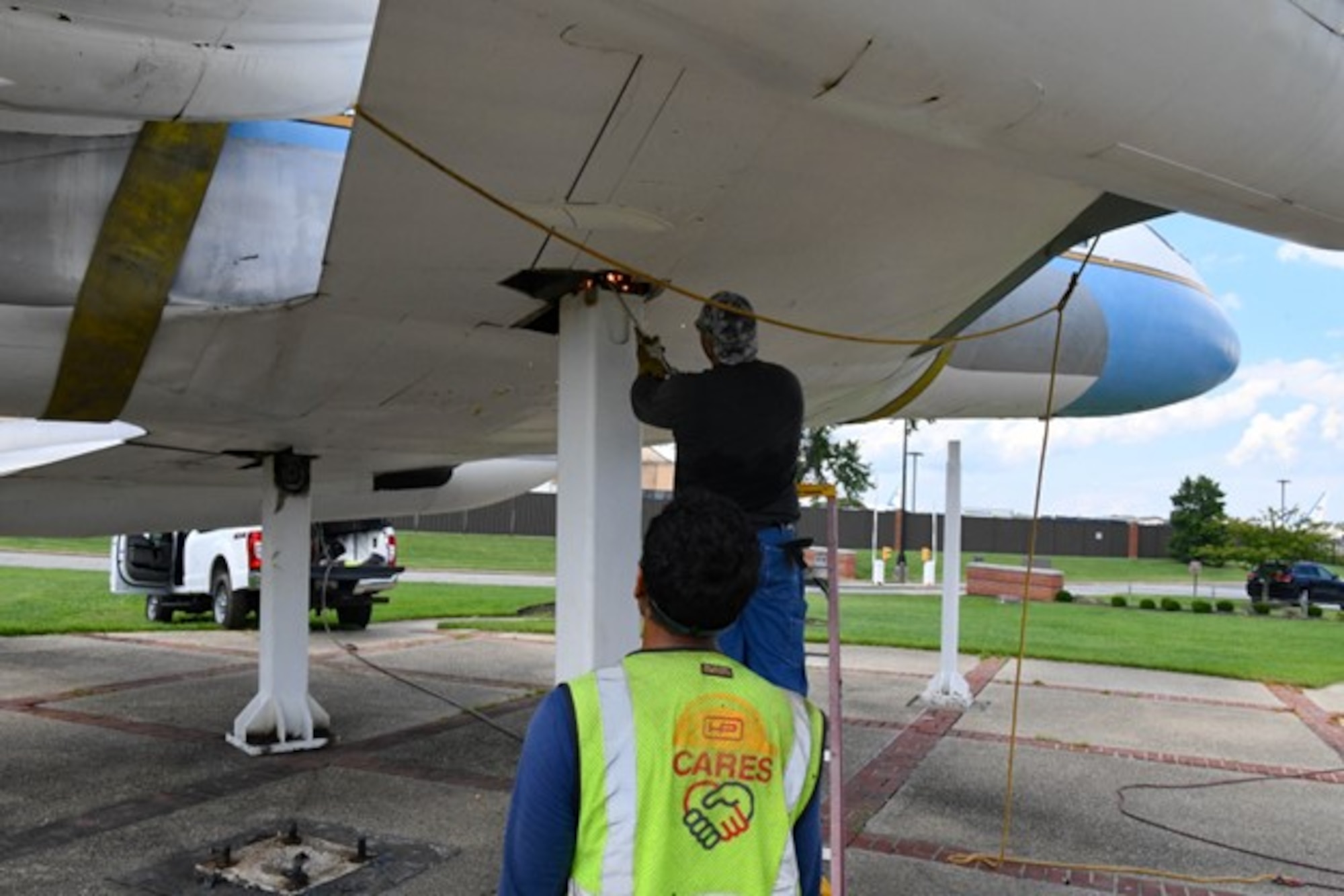 A contract worker cuts one of the pedestals holding a static U.S. Air Force Lockheed JetStar C-140B display aircraft in preparation for its relocation next to the 89th Airlift Wing headquarters building at Joint Base Andrews, Maryland, August 17, 2023. The C-140B aircraft were used for Military Airlift Command personnel transports, and also for 89 AW executive airlift operations where the planes were adorned with the distinctive blue and white with gold trim paint design associated with the Special Air Mission assignment and given the designation of VC-140B. (U.S. Air Force photo by Major Scott Terra)