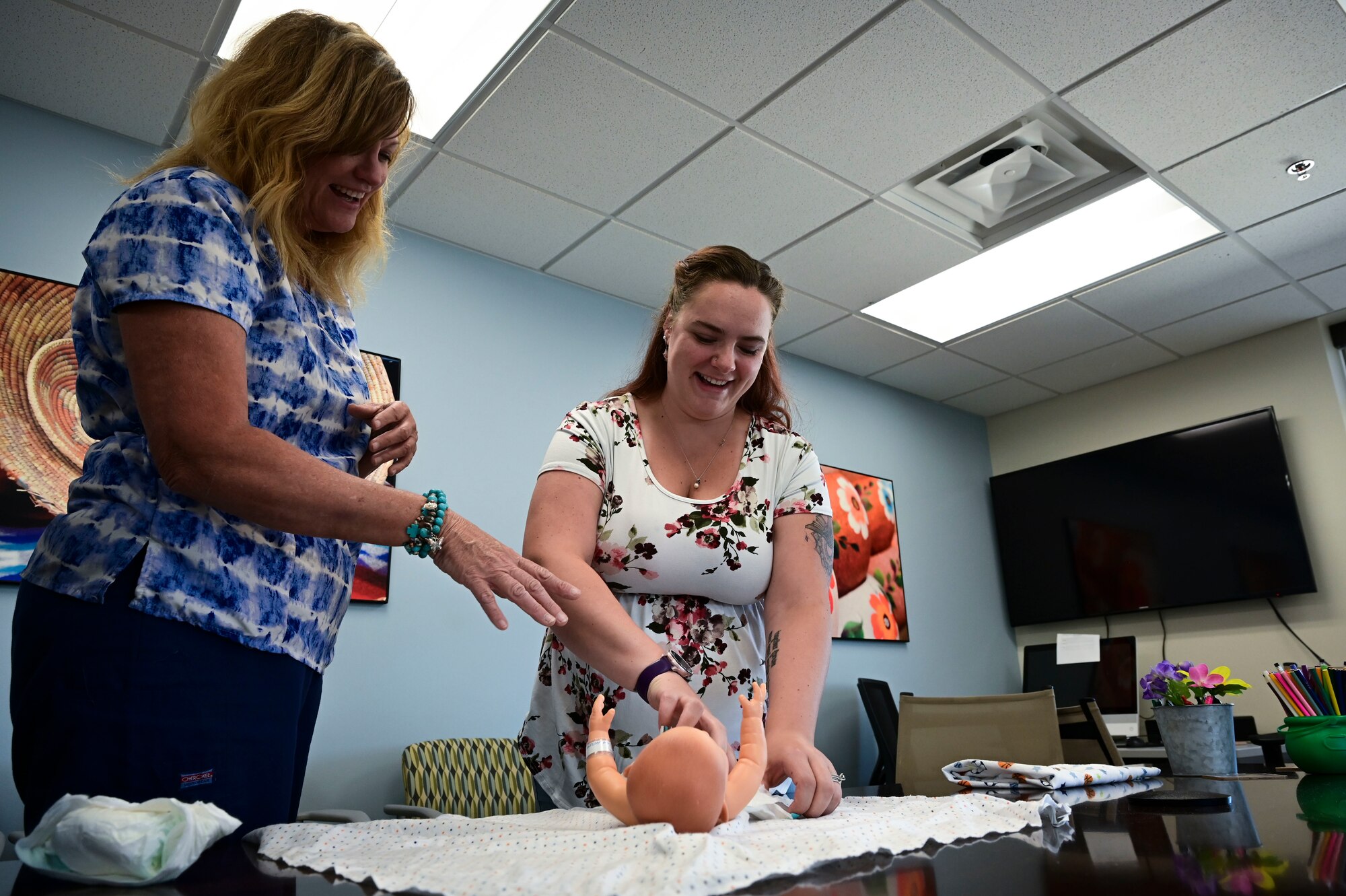 Candi Hutchins, 49th Medical Group parent support nurse, left, shows Katie Novotney, 49th MDG mental health receptionist, how to place a diaper on a doll during a Parents 101 class at Holloman Air Force Base, New Mexico, Aug. 16, 2023. The program is primarily geared towards parents in their third trimester, or for parents who need a refresher course on newborn or child management care. (U.S. Air Force photo by Airman 1st Class Isaiah Pedrazzini)