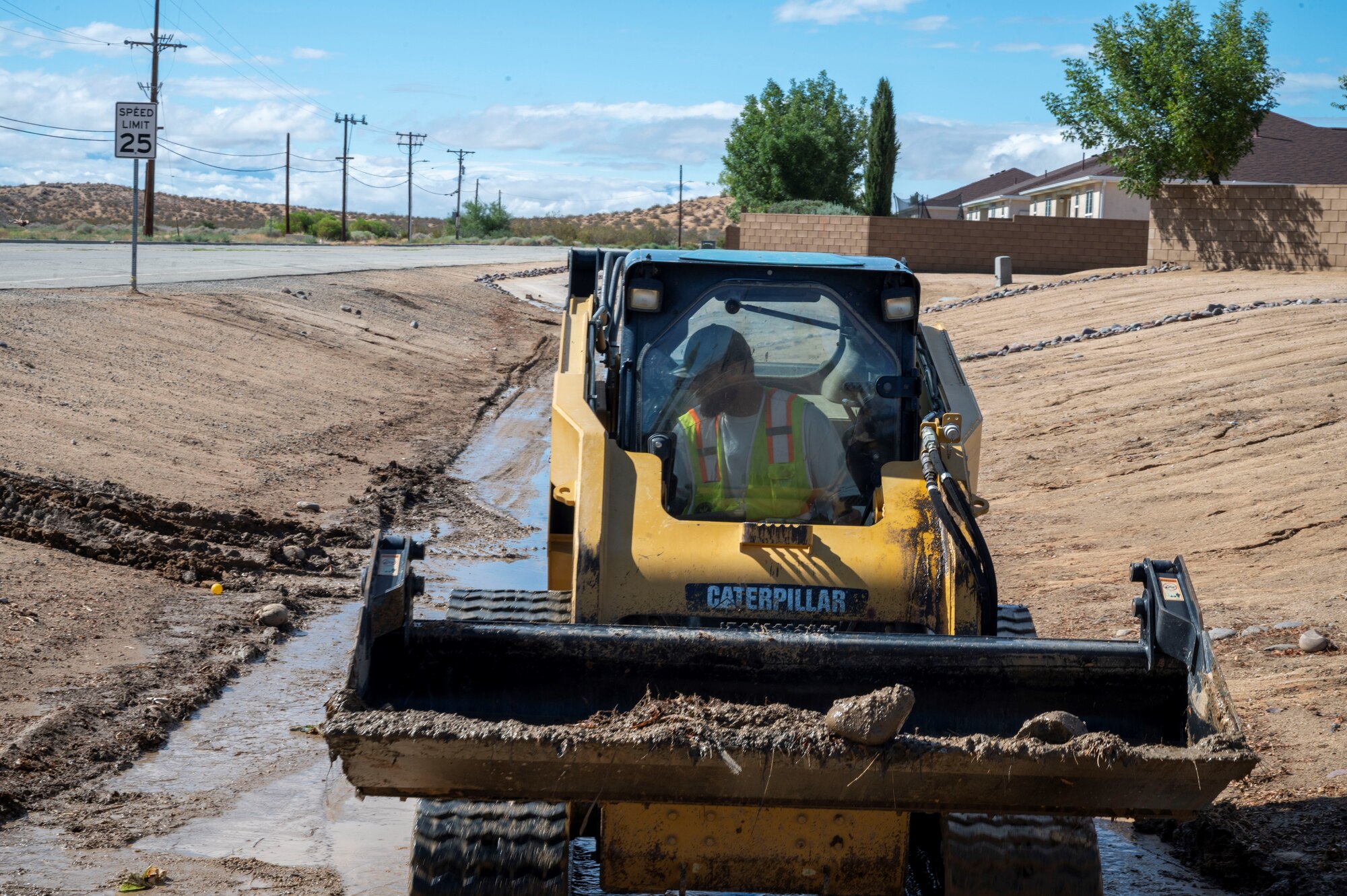 A 412th Civil Engineer Group worker clears mud and debris from the housing area Monday.