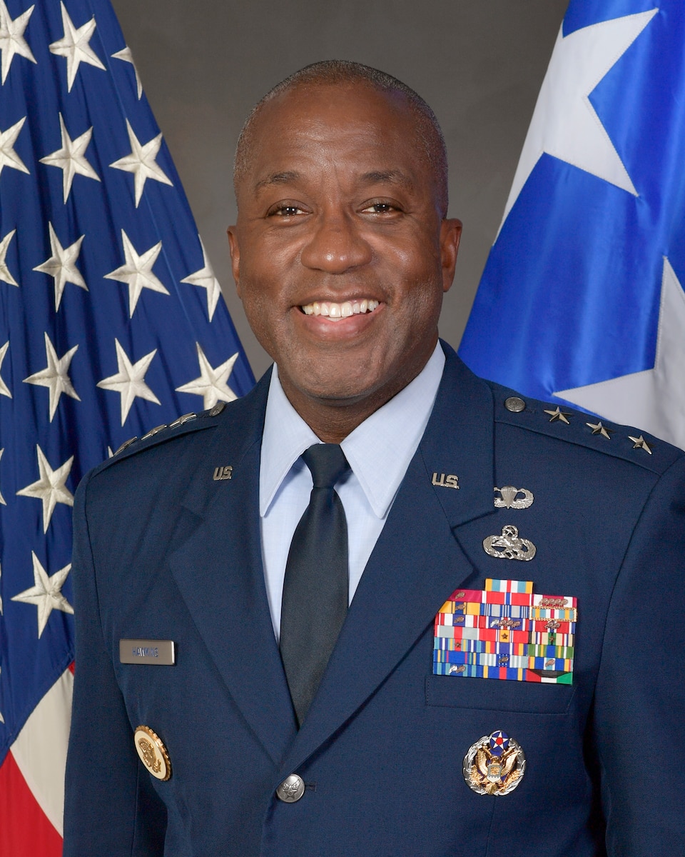 Photo of a 3-star general in front of flags.