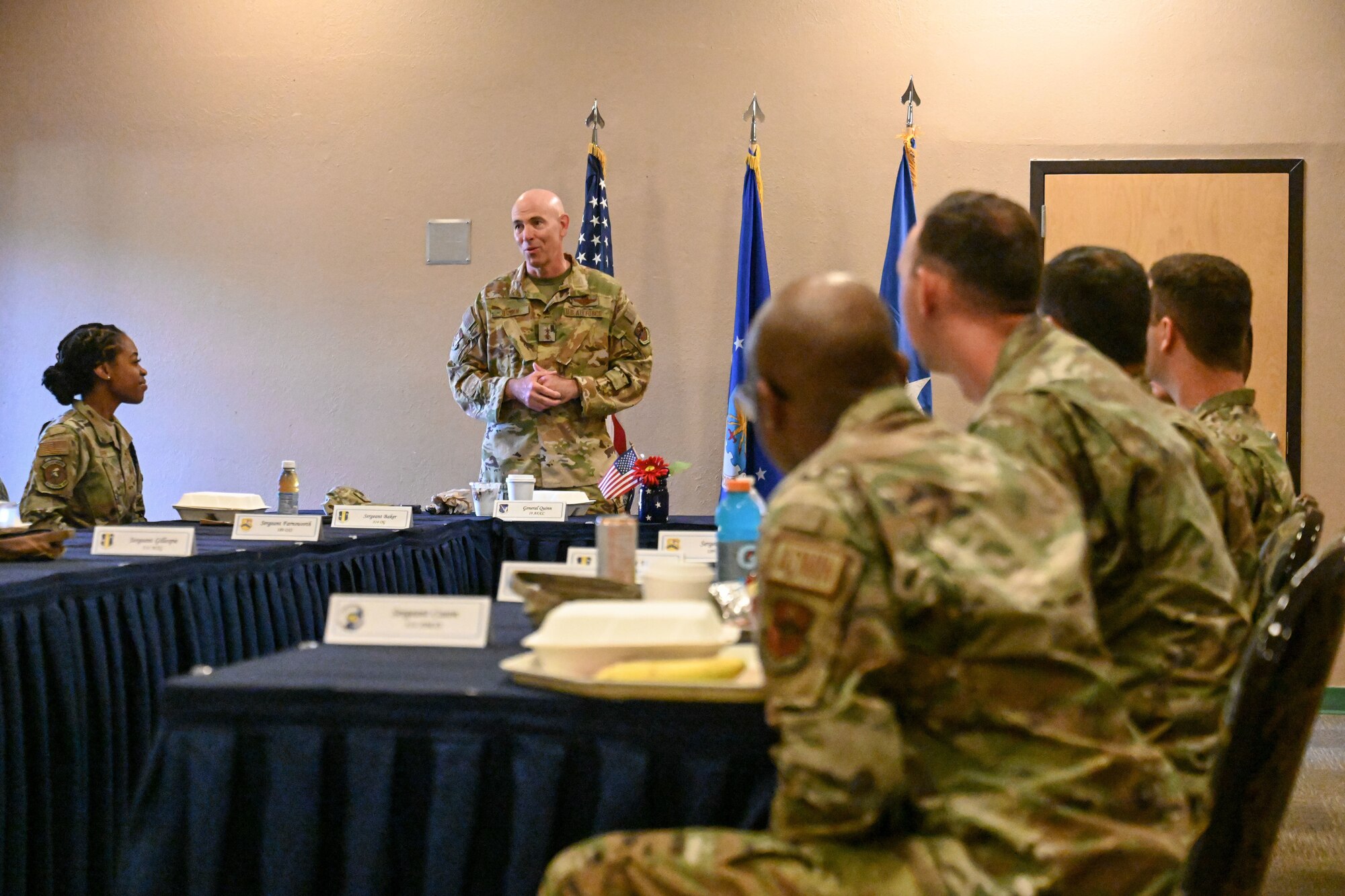 man in uniform speaks with Airmen
