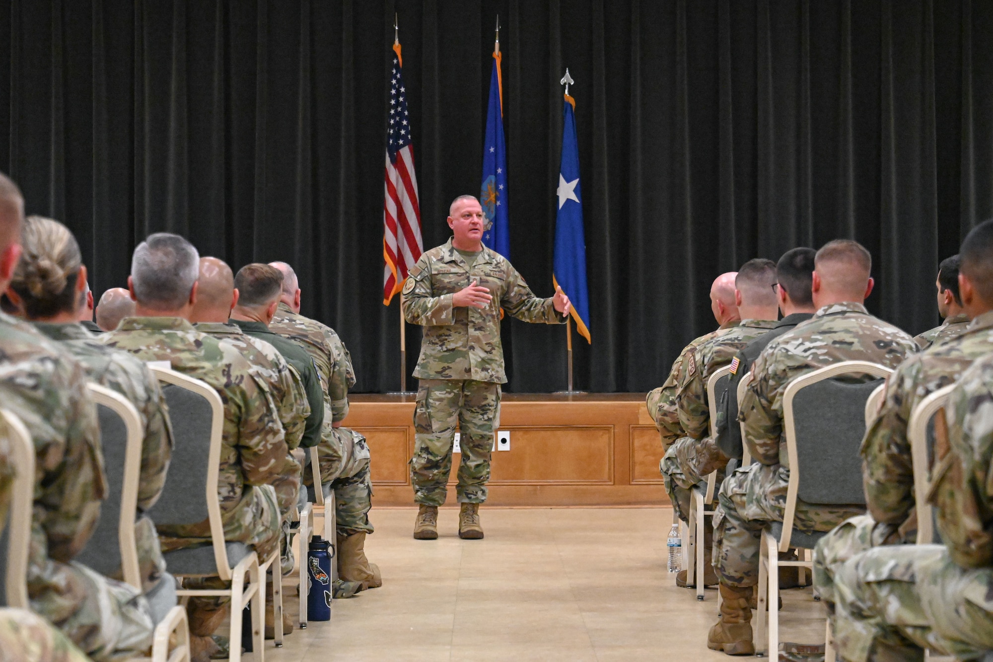 man in uniform speaks to Airmen