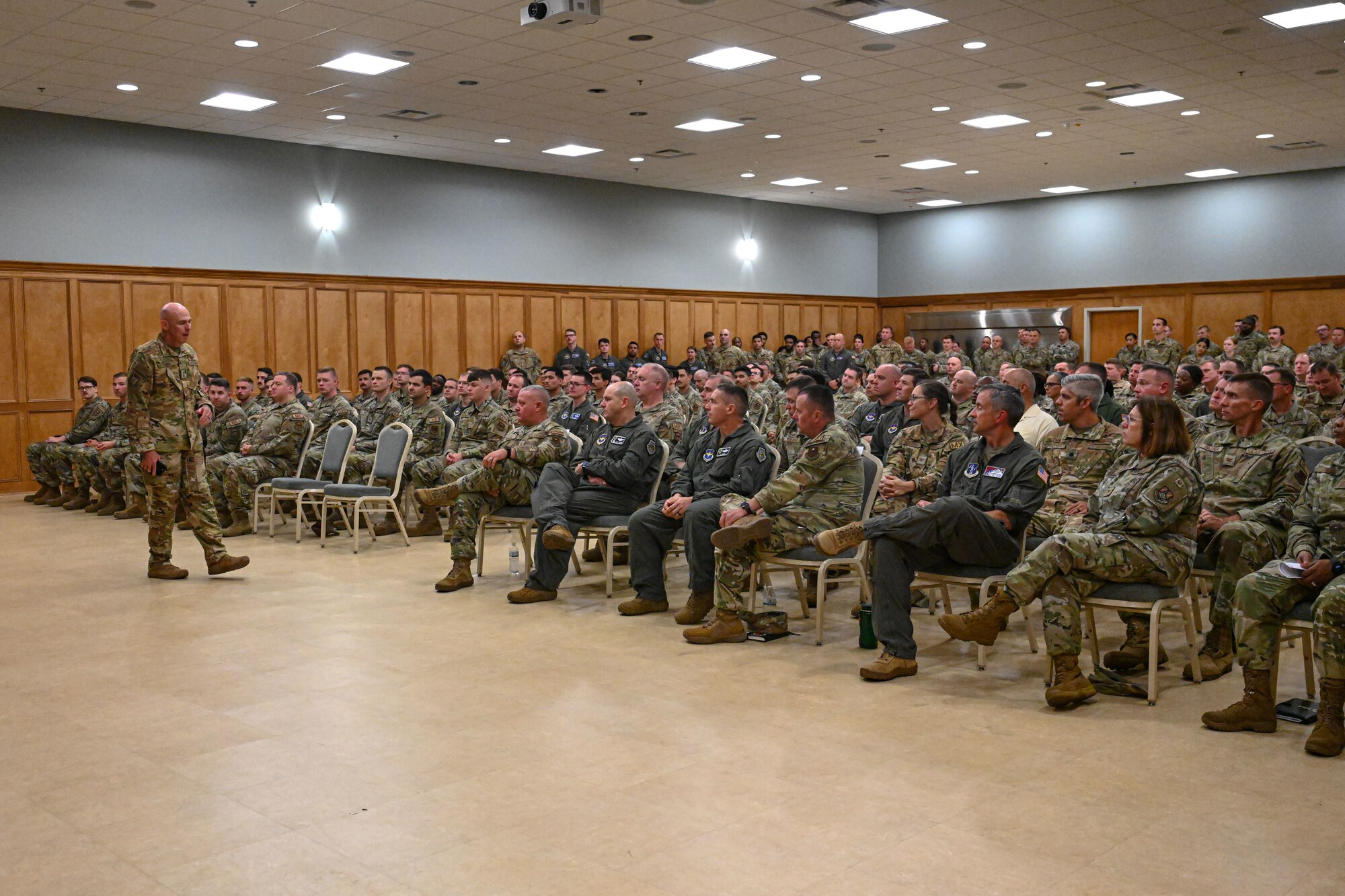 man in uniform speaks to Airmen
