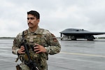 Airman stands in front of an aircraft.