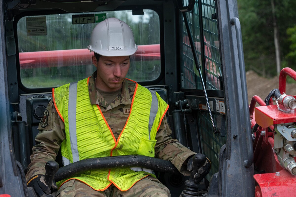 Senior Airman Hunter Olson, a 934th Airlift Wing Civil Engineering Squadron engineering apprentice, operates heavy machinery while upgrading Camp Mad Bull’s electrical system at Joint Base Elmendorf-Richardson, Alaska, on Aug. 9, 2023. The 934 AW CES was at the site for over two months in a series of 3 different rotations to effectively complete the mission. (Air Force photo by Senior Airman Matthew Reisdorf)