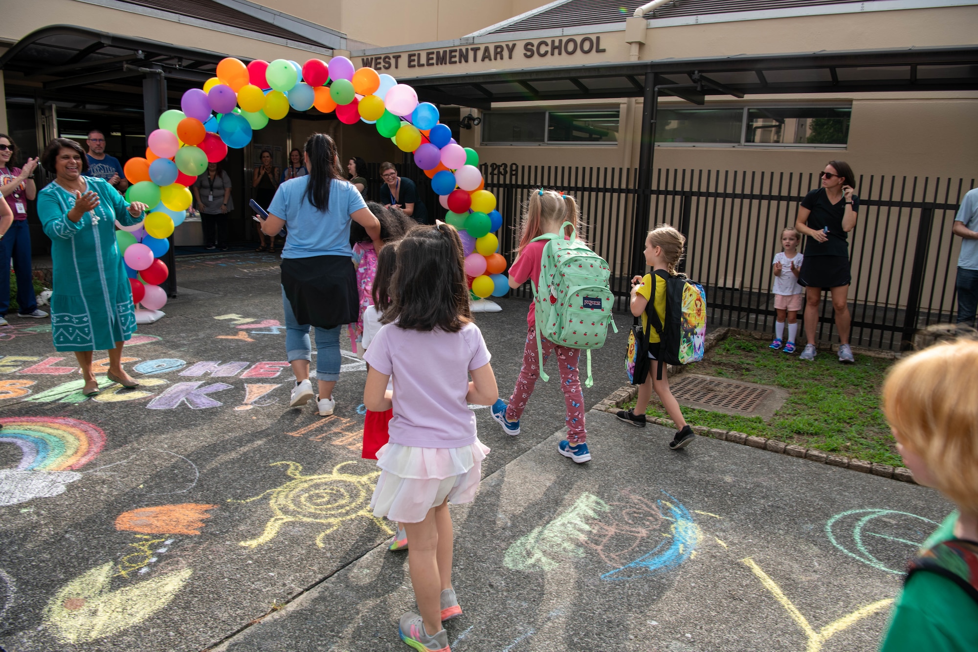 Students walk towards a school entrance.
