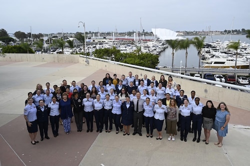 large group of uniformed U.S. military and civilian women standing together outside