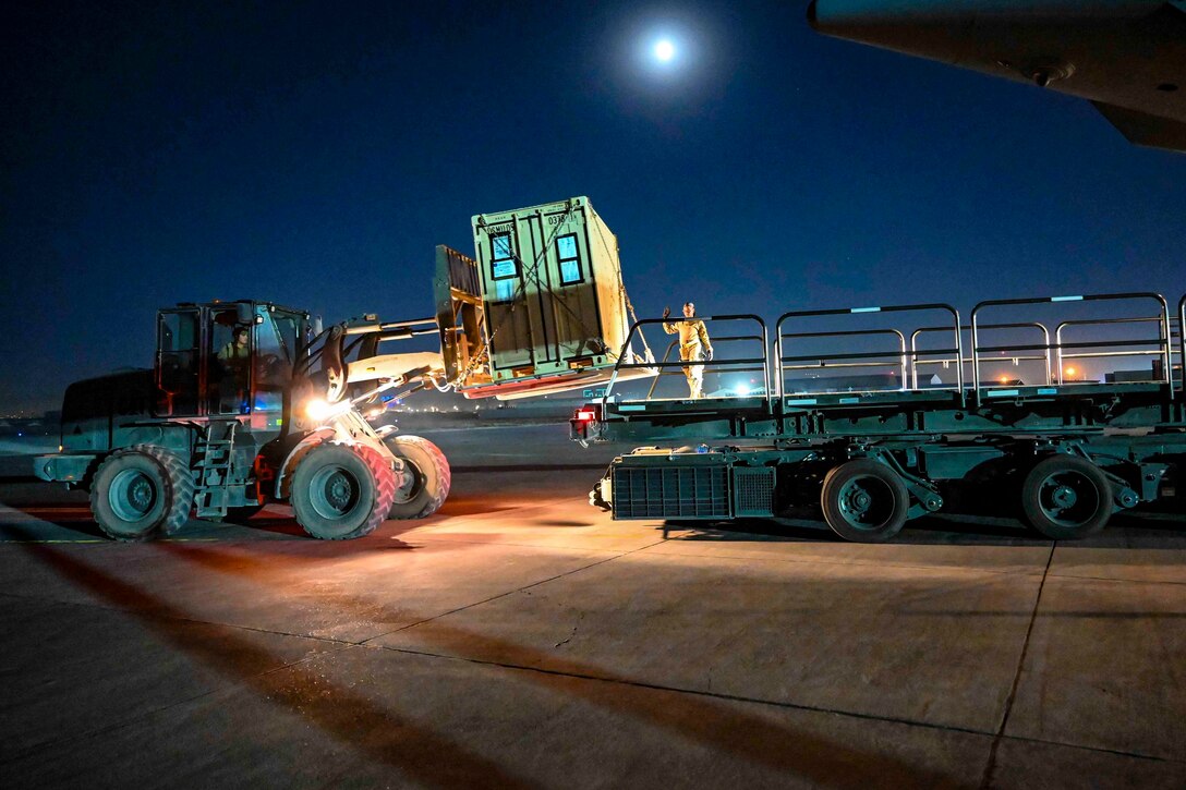 Airmen use a forklift to move equipment.