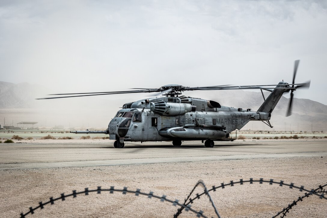 A CH-53E Super Stallion assigned to Marine Heavy Helicopter Squadron 361 (HMH-361), Marine Aircraft Group 16, 3rd Marine Aircraft Wing, sits on flightline, during Service Level Training Exercise (SLTE) 5-23, at Camp Wilson, Marine Corps Air-Ground Combat Center, Twentynine Palms, California, July 31, 2023. SLTE is a series of exercises meant to prepare the Marine Air-Ground Task Force for quick and effective responses to military operations. The MQ-8C has shown its capabilities of operating from ship to shore with a mobile control station and the ability to refuel from expeditionary locations in support of the Marine Corps' mission.