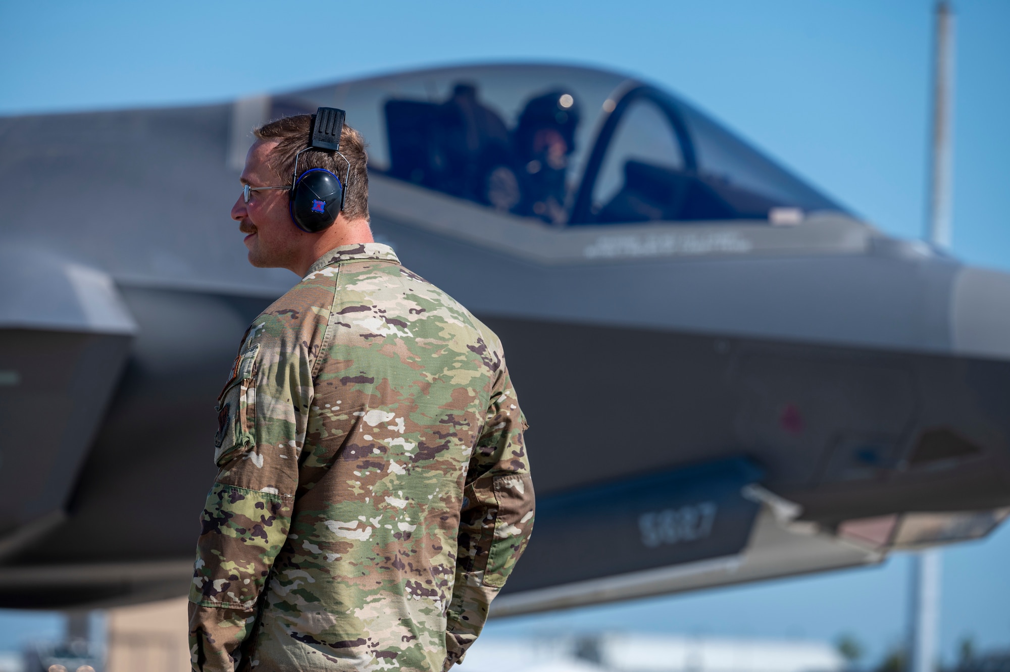 Airman standing in front of an F-35