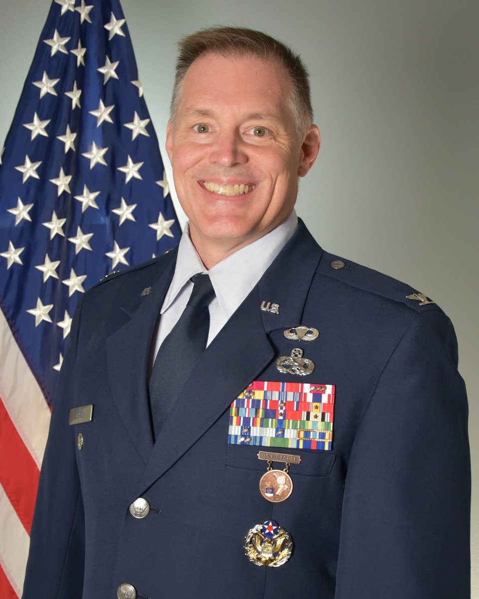 Man in uniform in front of a US flag