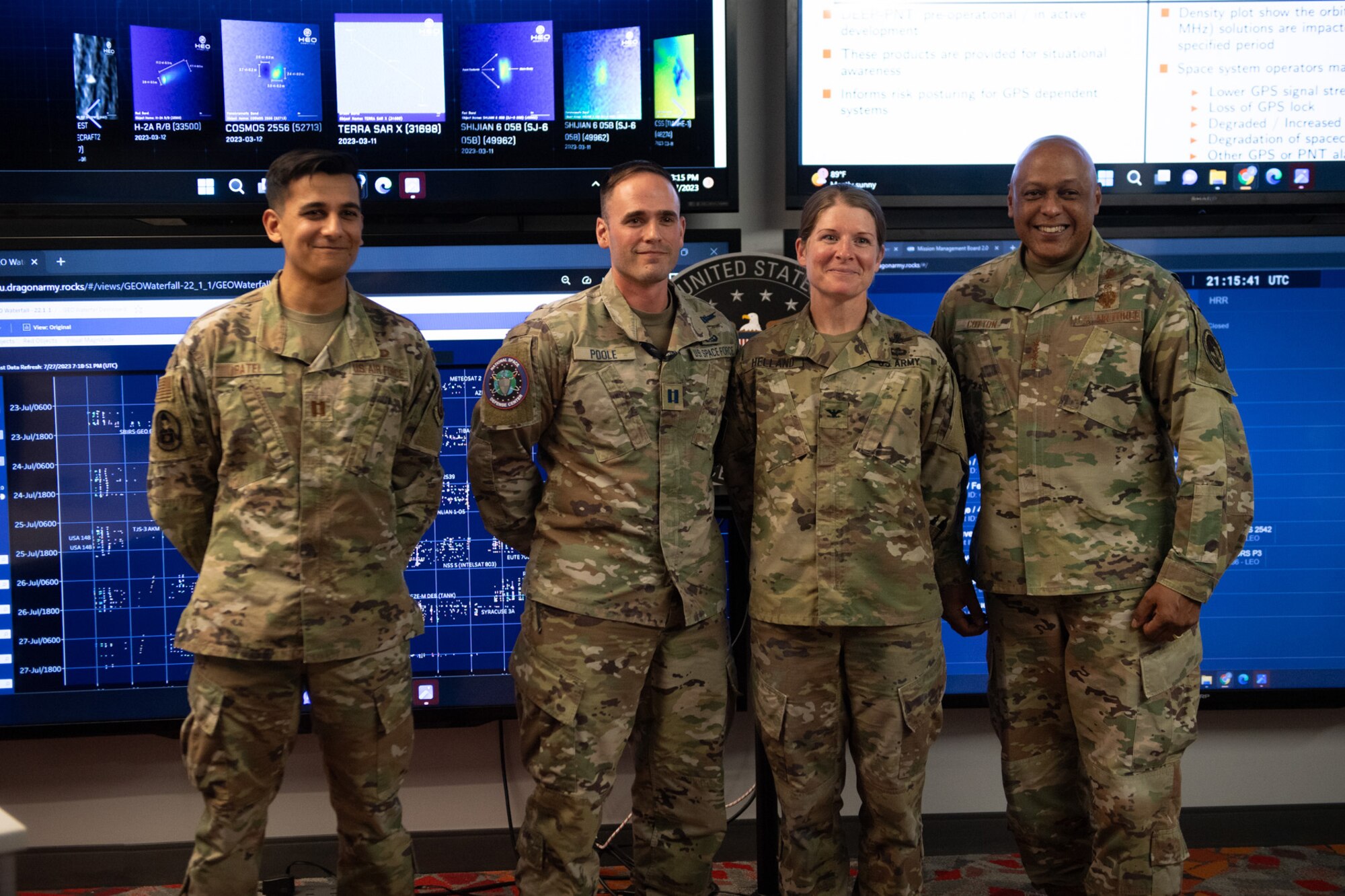 Four military members in uniform pose for a group photo