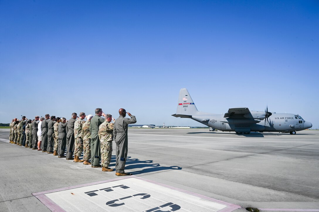 Georgia Air National Guardsmen, past and present, assigned to the 165th Airlift Wing located at Savannah Air National Guard Base, Georgia, salute a U.S. Air Force C-130 Hercules aircraft, tail number 31562, as it taxis on the flight line for the last time Aug. 18, 2023.