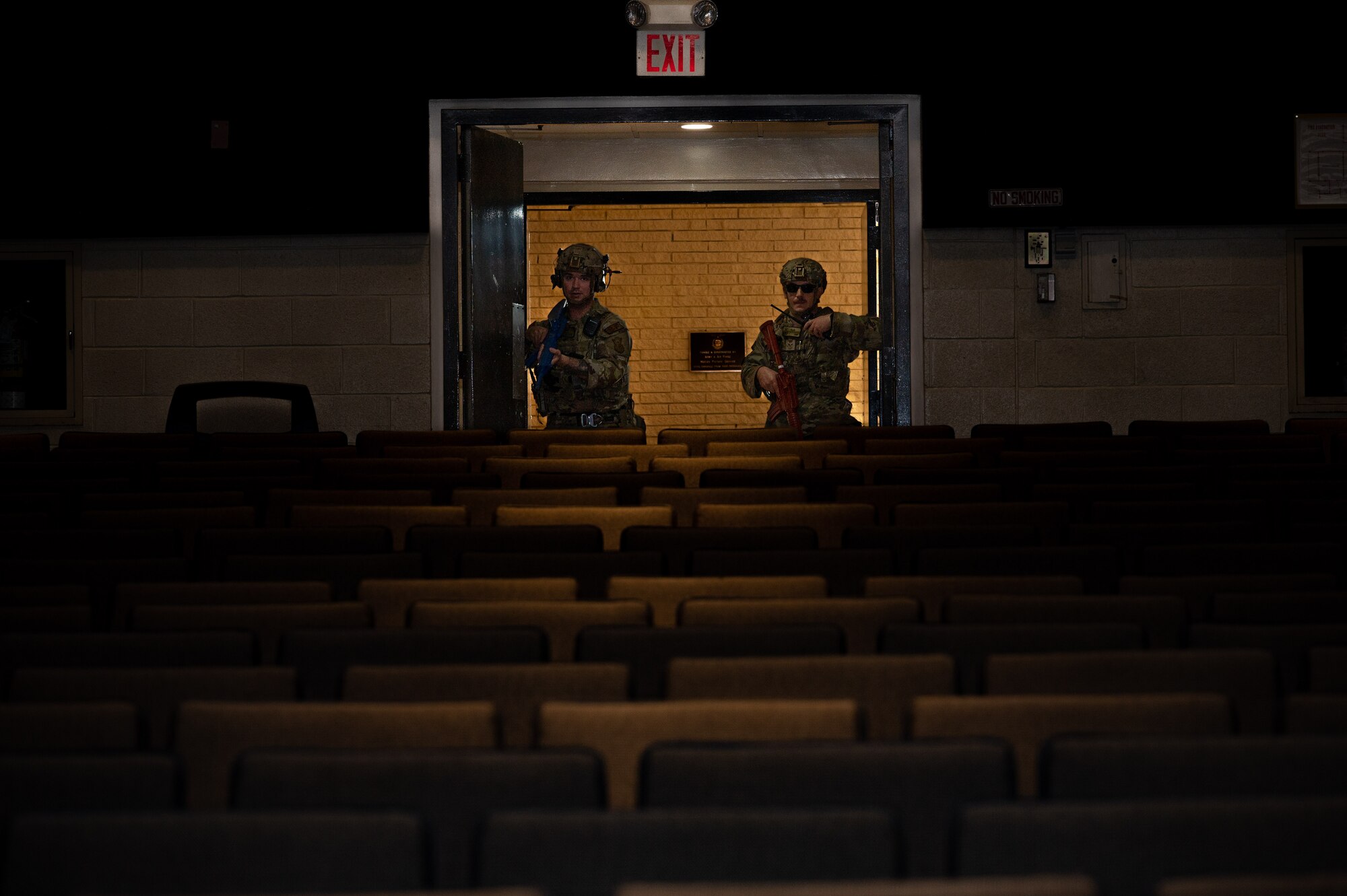 U.S. Air Force Airmen assigned to the 4th Security Forces Squadron enter a theater in response to a simulated active shooter threat during an active-shooter training exercise at Seymour Johnson Air Force Base, North Carolina, August 17, 2023. Airmen trained side-by-side with Wayne County first responders during the exercise to bolster communication and operational readiness between military and civilian personnel. (U.S. Air Force photo by Airman 1st Class Leighton Lucero)