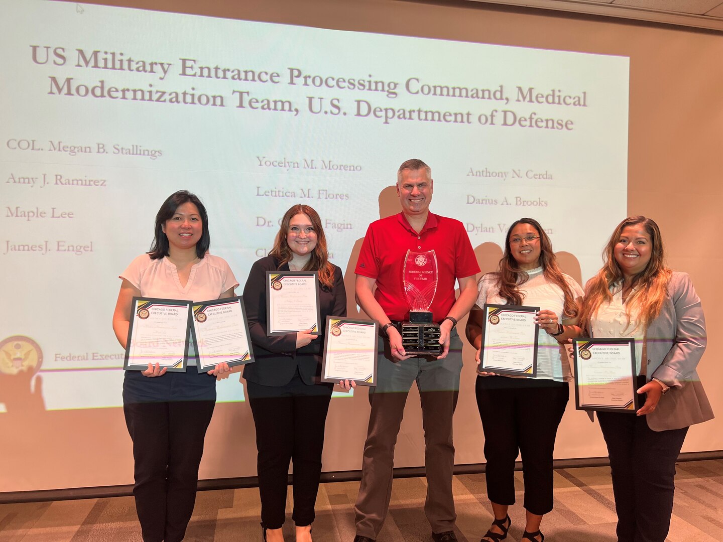 (From left to right) Maple Lee, Ashley Toomey, Jeff Engel, Leticia Flores, and Claudia Mora pose for a photo while holding certificates and a trophy for Agency of the Year at the Chicago Federal Executive Board's Employee of the Year Awards.