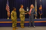 Dr. Katie Helland, director of Military Accession Policy, presents Chicago Federal Executive Board's Agency of the Year trophy to Col. Megan Stallings, USMEPCOM commander, and Command Sgt. Maj. Yveline Symonette, USMEPCOM senior enlisted advisor.