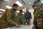 Personnel from the United States, Kazakhstan, Kyrgyzstan, Mongolia, Pakistan, Tajikistan and Uzbekistan work together Aug. 16, 2023, during Exercise Regional Cooperation 23 at the Helena Aviation Readiness Center in Helena, Montana. The Montana National Guard hosted RC23, annual, multinational exercise conducted by U.S. forces in partnership with Central and South Asian nations.