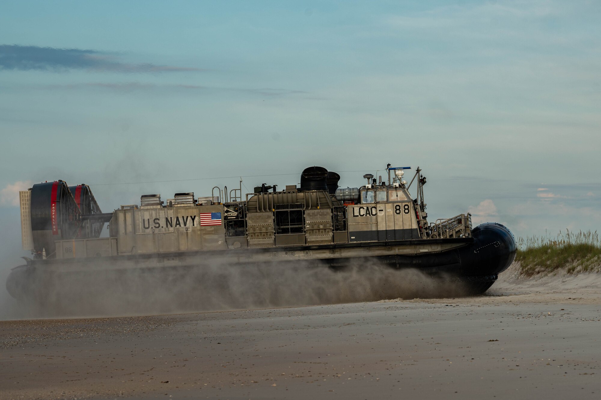 Navy Expeditionary Combat Command Seabees assigned to Naval Mobile Construction Battalion 11 are delivered to shore by U.S. Navy Landing Craft, Air Cushion (LCAC) 88 at Onslow Beach, Marine Corps Base Camp Lejeune, North Carolina, August 9, 2023, during Large-Scale Exercise 2023 (LSE 2023). LSE 2023 demonstrates the Navy’s and Marine Corps’ ability to employ precise, lethal, and overwhelming force globally across six maritime component commands, seven numbered fleets, and 22 time zones. LSE 2023 merges real-world operations with virtually constructed scenarios to create a realistic training environment that allows Sailors and Marines to train how they will fight, regardless of geographic boundaries. (U.S. Air Force photo by Airman 1st Class Rebecca Sirimarco-Lang)