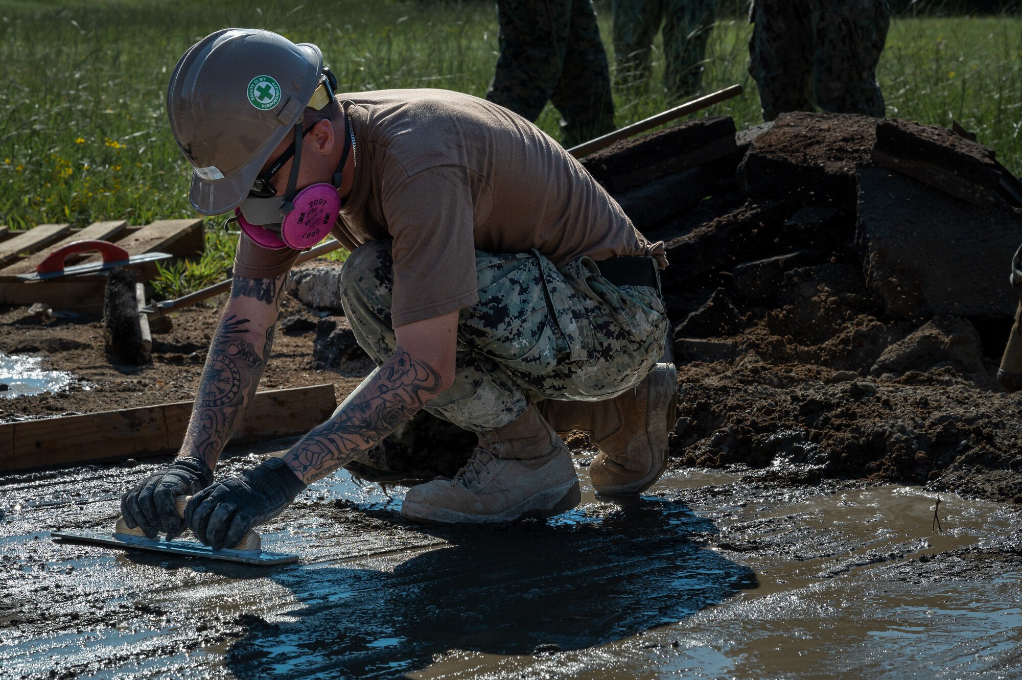 Navy Expeditionary Combat Command Seabees assigned to Naval Mobile Construction Battalion 11 level out wet concrete to fill a crater on an airfield ramp during airfield damage repair efforts as part of Large Scale Exercise (LSE) 2023 at Seymour Johnson Air Force Base, North Carolina, July 10, 2023. LSE 2023 demonstrates the Navy’s and Marine Corps’ ability to employ precise, lethal, and overwhelming force globally across six maritime component commands, seven numbered fleets, and 22 time zones. LSE 2023 merges real-world operations with virtually constructed scenarios to create a realistic training environment that allows Sailors and Marines to train how they will fight, regardless of geographic boundaries. (U.S. Air Force photo by Airman 1st Class Leighton Lucero)