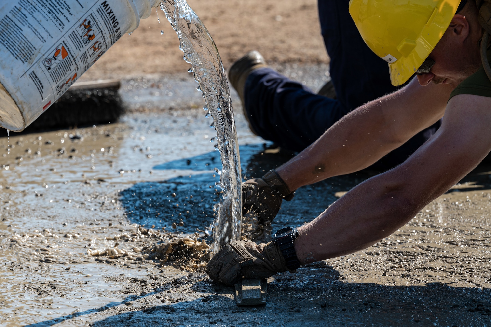 A U.S. Navy Sailor levels out wet concrete to fill a crater on an airfield ramp during Large Scale Exercise (LSE) 2023 at Seymour Johnson Air Force Base, North Carolina, July 10, 2023. LSE 2023 demonstrates the Navy’s and Marine Corps’ ability to employ precise, lethal, and overwhelming force globally across six maritime component commands, seven numbered fleets, and 22 time zones. LSE 2023 merges real-world operations with virtually constructed scenarios to create a realistic training environment that allows Sailors and Marines to train how they will fight, regardless of geographic boundaries. (U.S. Air Force photo by Airman 1st Class Leighton Lucero)