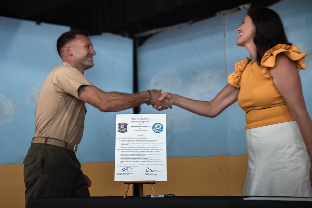 U.S. Marine Corps Lt. Col. Matthew J. Schults, commanding officer, Marine Wing Support Squadron 174, Marine Aircraft Group 24, signs an agreement during an Adopt-A-School ceremony at Aikahi Elementary School in Kailua, Hawaii, Aug. 3, 2023. MWSS-174 and Aikahi Elementary School signed a Proclamation of Understanding to assist staff in various tasks such as mentoring and community service. (U.S. Marine Corps photo by Cpl. Christian Tofteroo)