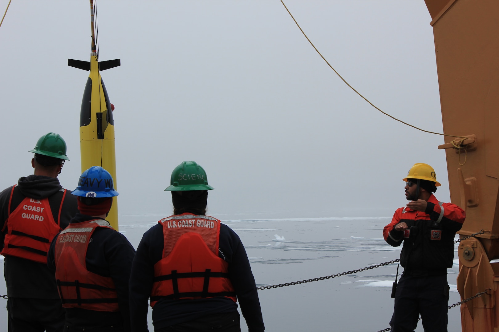 Petty Officer 3rd Class Blake Wilson, a Coast Guard Cutter Healy (WAGB 20) crew member, leads deck force in deployment of an Arctic Mobile Observing System glider in the Beaufort Sea, July 29, 2023. The crew conducts science stations in the Beaufort Sea as a part of Healy’s primary mission, and the Healy is designed to conduct a wide range of research activities, providing more than 4,200 square feet of scientific laboratory space, numerous electronic sensor systems, oceanographic winches, and accommodations for up to 50 scientists. (Coast Guard photo by Ensign Zane Miagany)