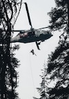 A Naval Air Station Whidbey Island crew member rappels during rescue.