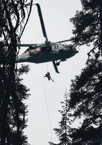 A Naval Air Station Whidbey Island crew member rappels during rescue.