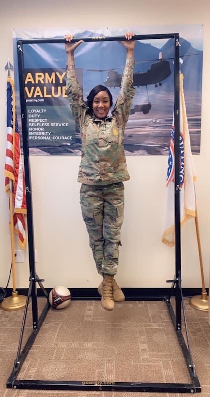 A female Soldier demonstrates a pull up in a recruiting station.